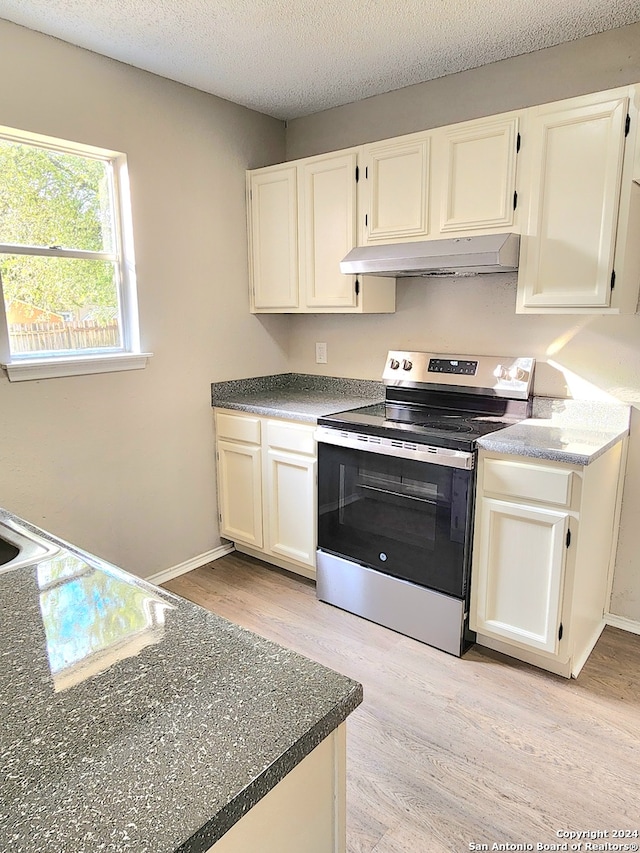 kitchen featuring light hardwood / wood-style floors, white cabinets, and electric stove