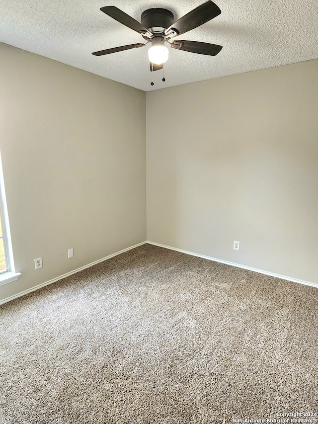 carpeted empty room with ceiling fan and a textured ceiling