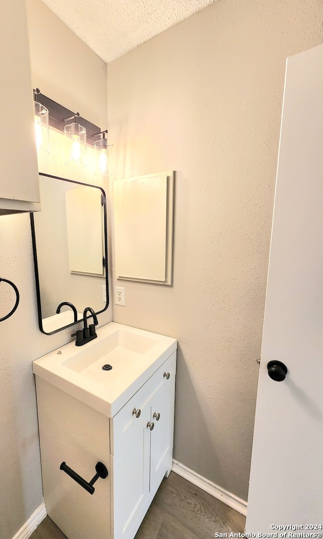 bathroom with vanity, a textured ceiling, and wood-type flooring