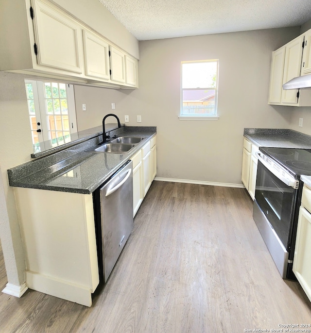 kitchen with white cabinets, a textured ceiling, light hardwood / wood-style flooring, stainless steel appliances, and sink