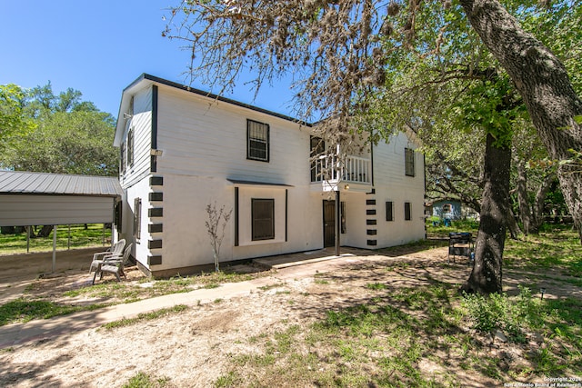 back of house featuring a carport and a balcony