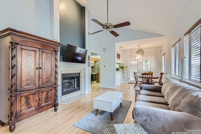 living room featuring high vaulted ceiling, a healthy amount of sunlight, and light hardwood / wood-style flooring