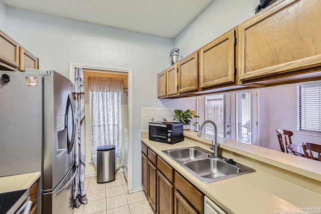 kitchen with stainless steel fridge, sink, and light tile patterned floors