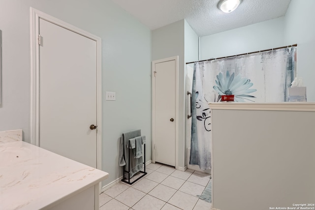 bathroom with vanity, a textured ceiling, and tile patterned floors