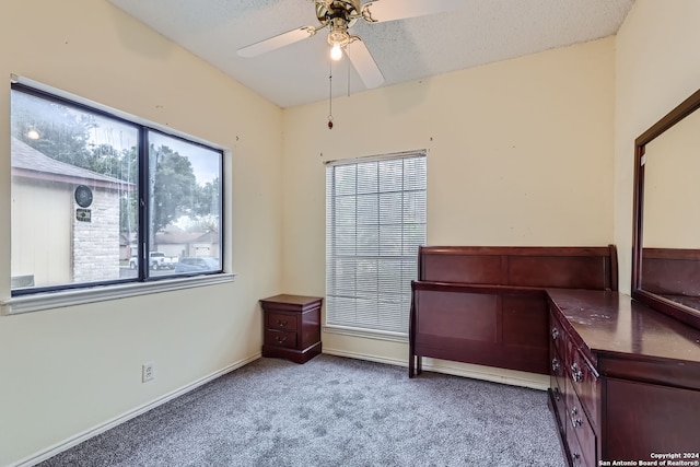 bedroom featuring a textured ceiling, carpet flooring, and ceiling fan