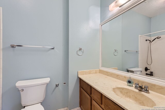 bathroom featuring vanity, a shower, a textured ceiling, and toilet