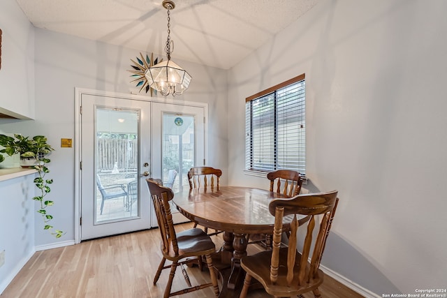 dining room with an inviting chandelier, french doors, and light hardwood / wood-style floors