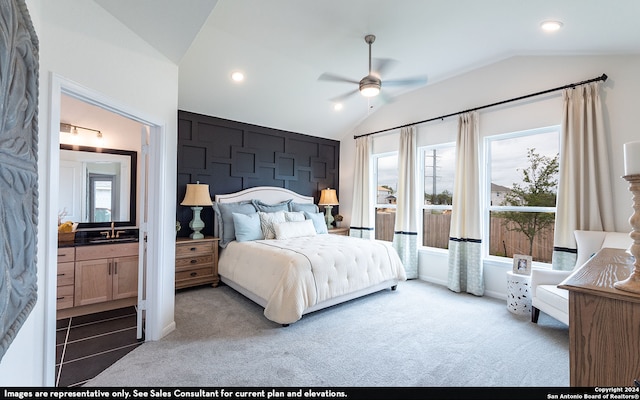 bedroom with lofted ceiling, ceiling fan, carpet floors, and connected bathroom