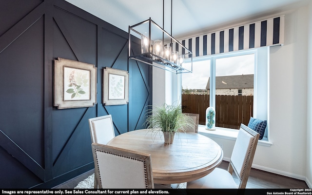 dining space with dark hardwood / wood-style flooring and a chandelier