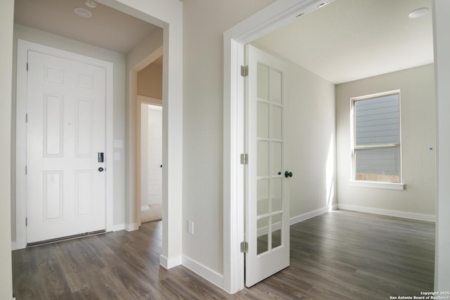 corridor with dark wood-type flooring and baseboards