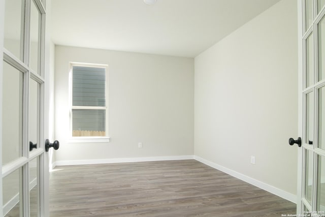 unfurnished room featuring dark wood-style floors, french doors, and baseboards