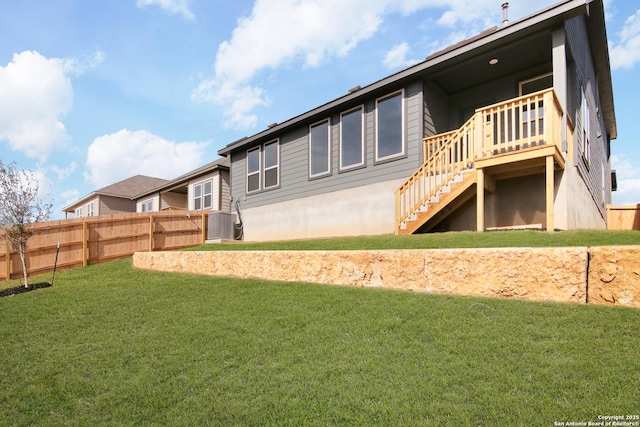 back of property featuring a yard, stairway, and fence