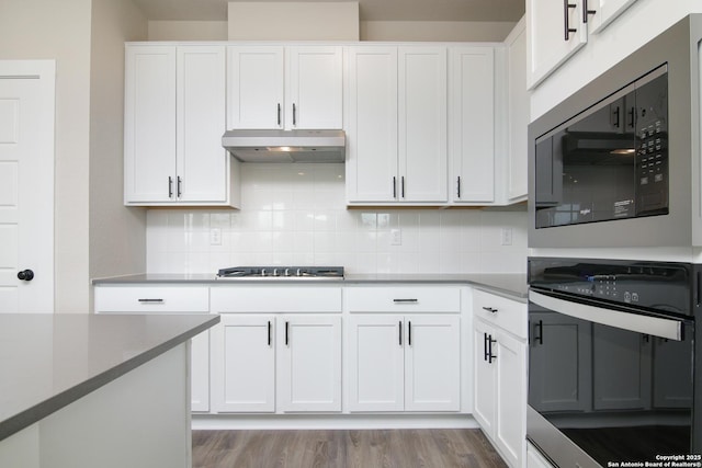 kitchen featuring stainless steel appliances, light wood-style flooring, white cabinetry, and under cabinet range hood