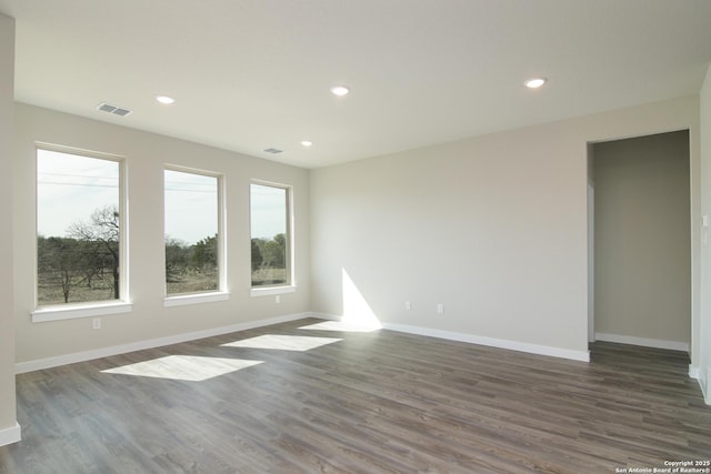 unfurnished room featuring baseboards, visible vents, dark wood-type flooring, and recessed lighting