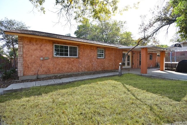 rear view of house featuring a yard and a patio