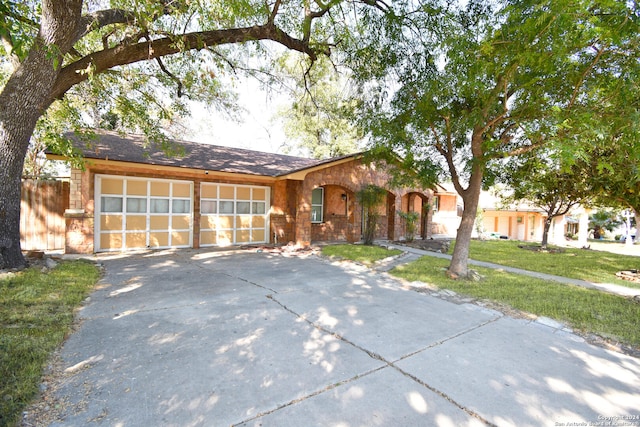 single story home with a front yard and a garage