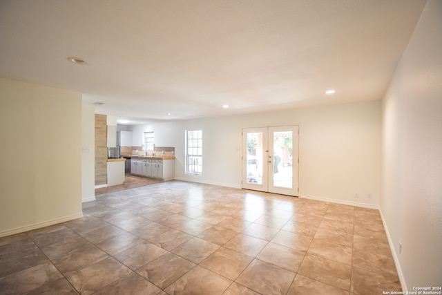 unfurnished living room featuring french doors and light tile patterned floors