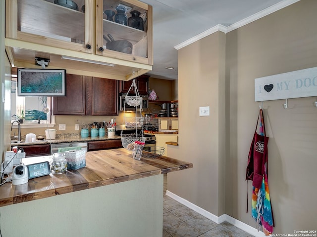 414 E Hathaway Dr, San Antonio, TX 78209 - kitchen featuring ornamental molding, light tile patterned flooring, dark brown cabinets, butcher block countertops, and baseboards