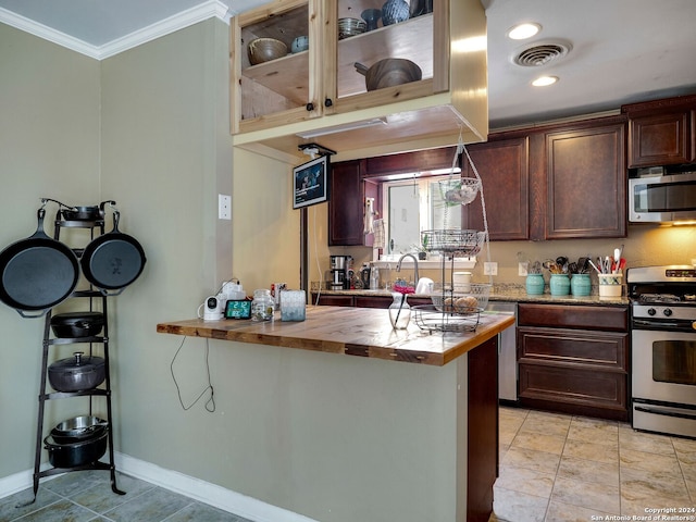 kitchen featuring kitchen peninsula, a kitchen bar, ornamental molding, stainless steel appliances, and butcher block countertops