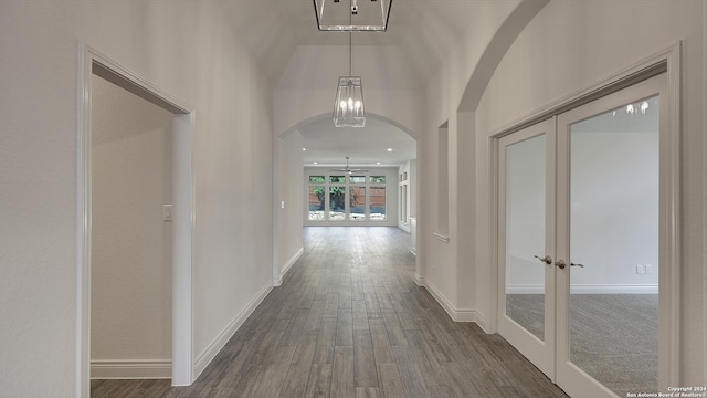 corridor featuring french doors, vaulted ceiling, and dark hardwood / wood-style floors