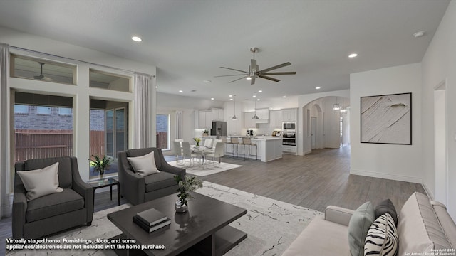 living room with light wood-type flooring and ceiling fan