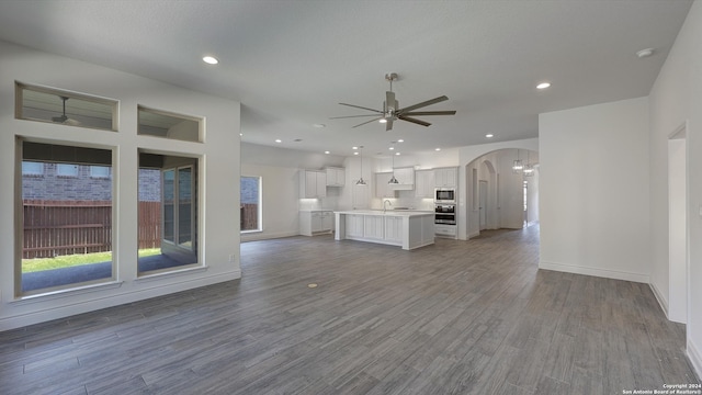 unfurnished living room featuring light hardwood / wood-style floors and ceiling fan