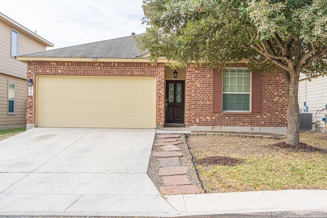 view of front of house with a garage and central air condition unit