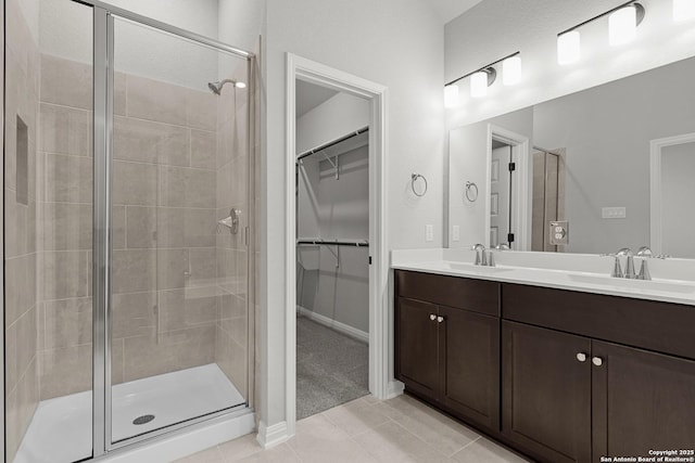 full bath featuring a sink, tile patterned floors, and a shower stall