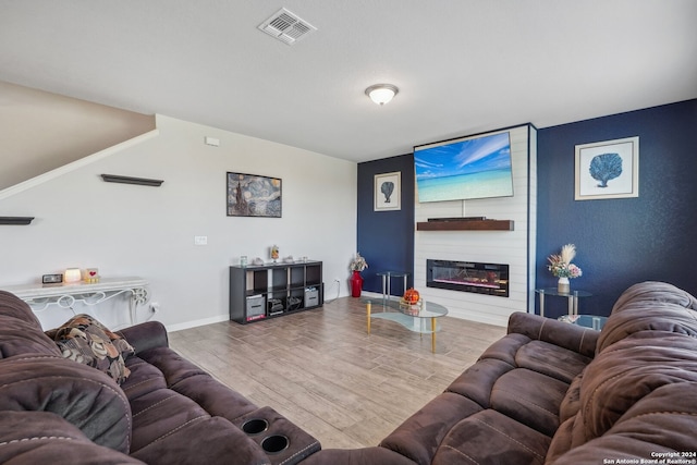 living room featuring wood-type flooring and a fireplace