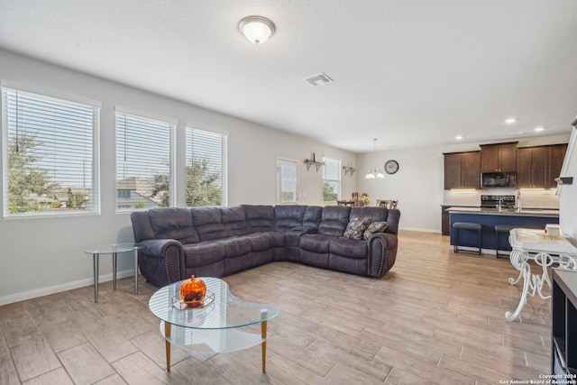 living room featuring a notable chandelier and light wood-type flooring