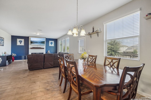 dining room with light hardwood / wood-style flooring and an inviting chandelier