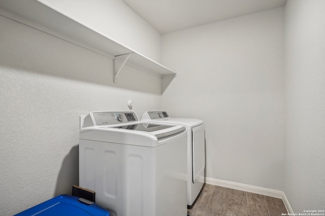 laundry area with hardwood / wood-style flooring and washer and clothes dryer