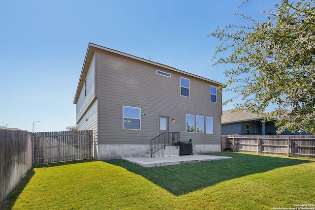 rear view of house featuring a patio and a yard