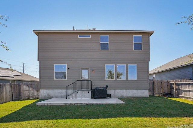 back of property with a patio area and a lawn