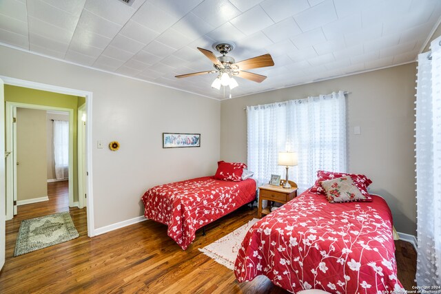 bedroom with dark hardwood / wood-style floors and ceiling fan