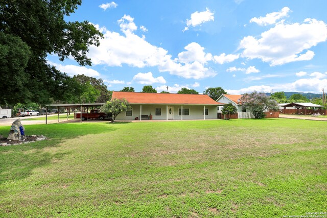 exterior space featuring a porch, a lawn, and a carport