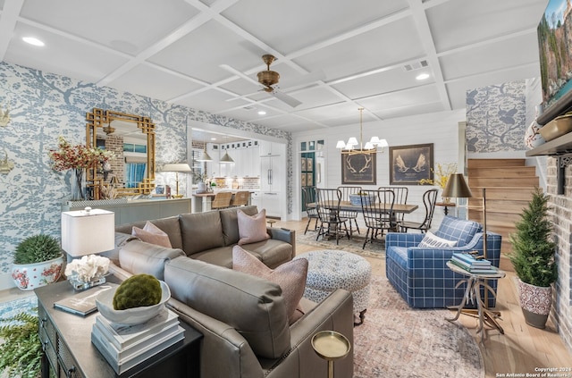 living room featuring hardwood / wood-style floors, coffered ceiling, and ceiling fan with notable chandelier