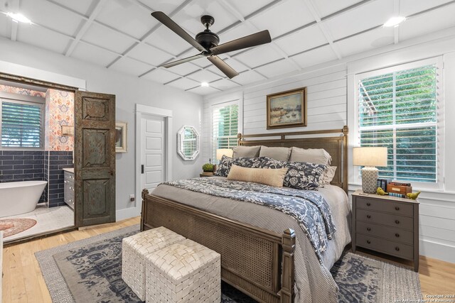 bedroom with multiple windows, light hardwood / wood-style floors, and ceiling fan