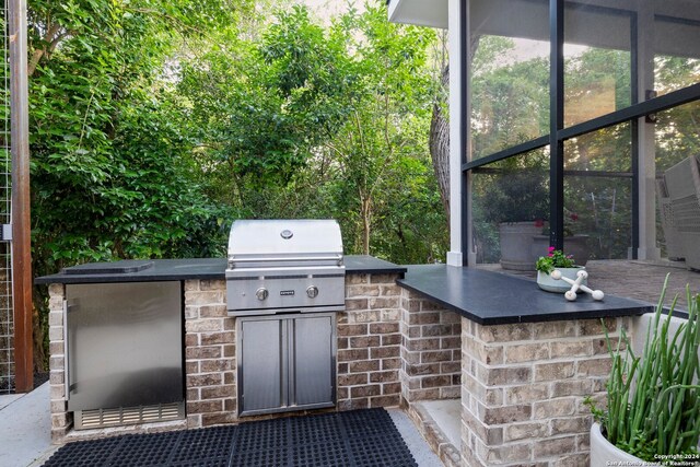 view of patio featuring an outdoor kitchen and a grill