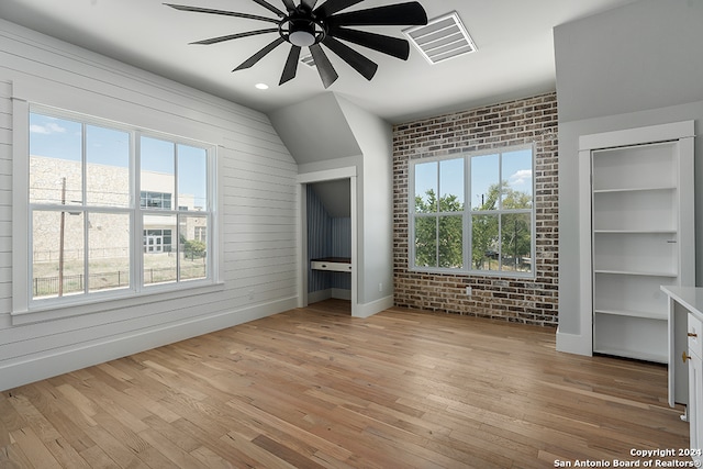 unfurnished bedroom featuring ceiling fan, multiple windows, and light wood-type flooring