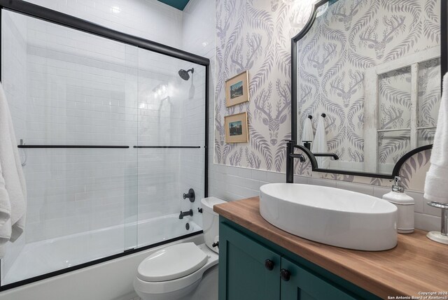 full bathroom with vanity, toilet, and shower / bath combination with glass door