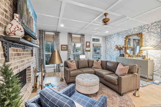 living room with hardwood / wood-style floors, coffered ceiling, a fireplace, and ceiling fan