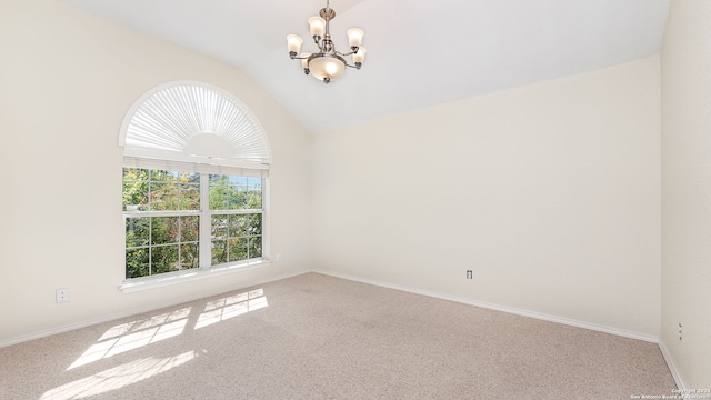 empty room with carpet, vaulted ceiling, and a notable chandelier