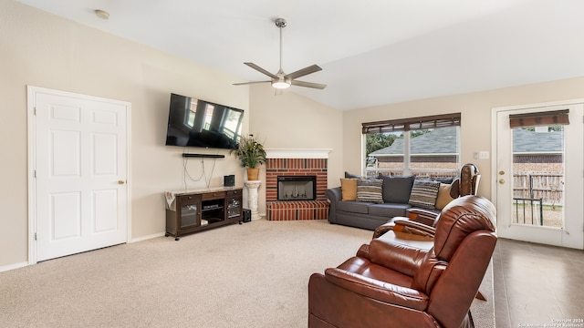 living room featuring vaulted ceiling, a brick fireplace, carpet floors, and ceiling fan