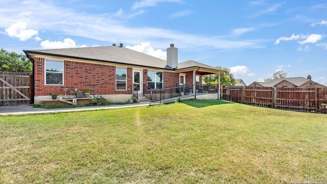 1042 Segovia, New Braunfels, TX 78130 - rear view of property with a chimney, a yard, brick siding, and a fenced backyard