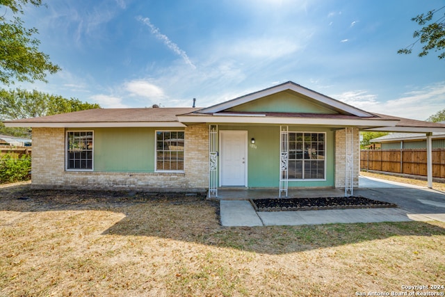 view of front of home with a front yard, fence, a porch, and brick siding