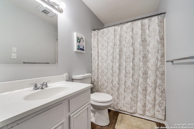 full bathroom with visible vents, toilet, vanity, wood finished floors, and a shower with curtain