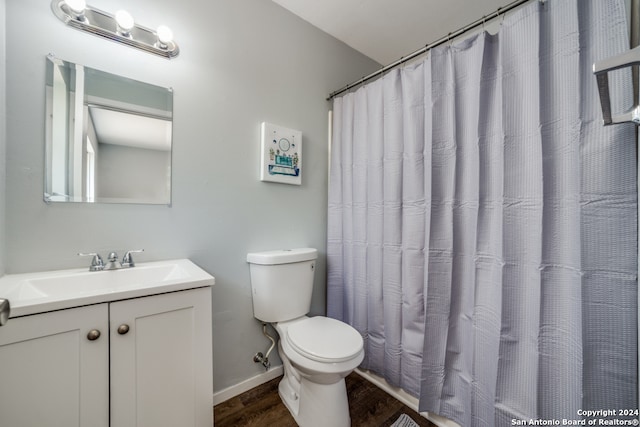 full bathroom featuring toilet, vanity, wood finished floors, a shower with curtain, and baseboards