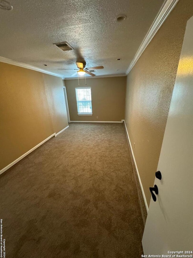 carpeted spare room featuring crown molding, a textured ceiling, and ceiling fan