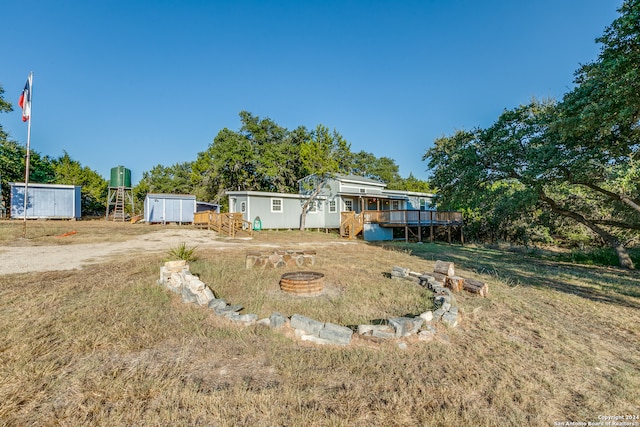 view of yard featuring a fire pit, a shed, and a deck